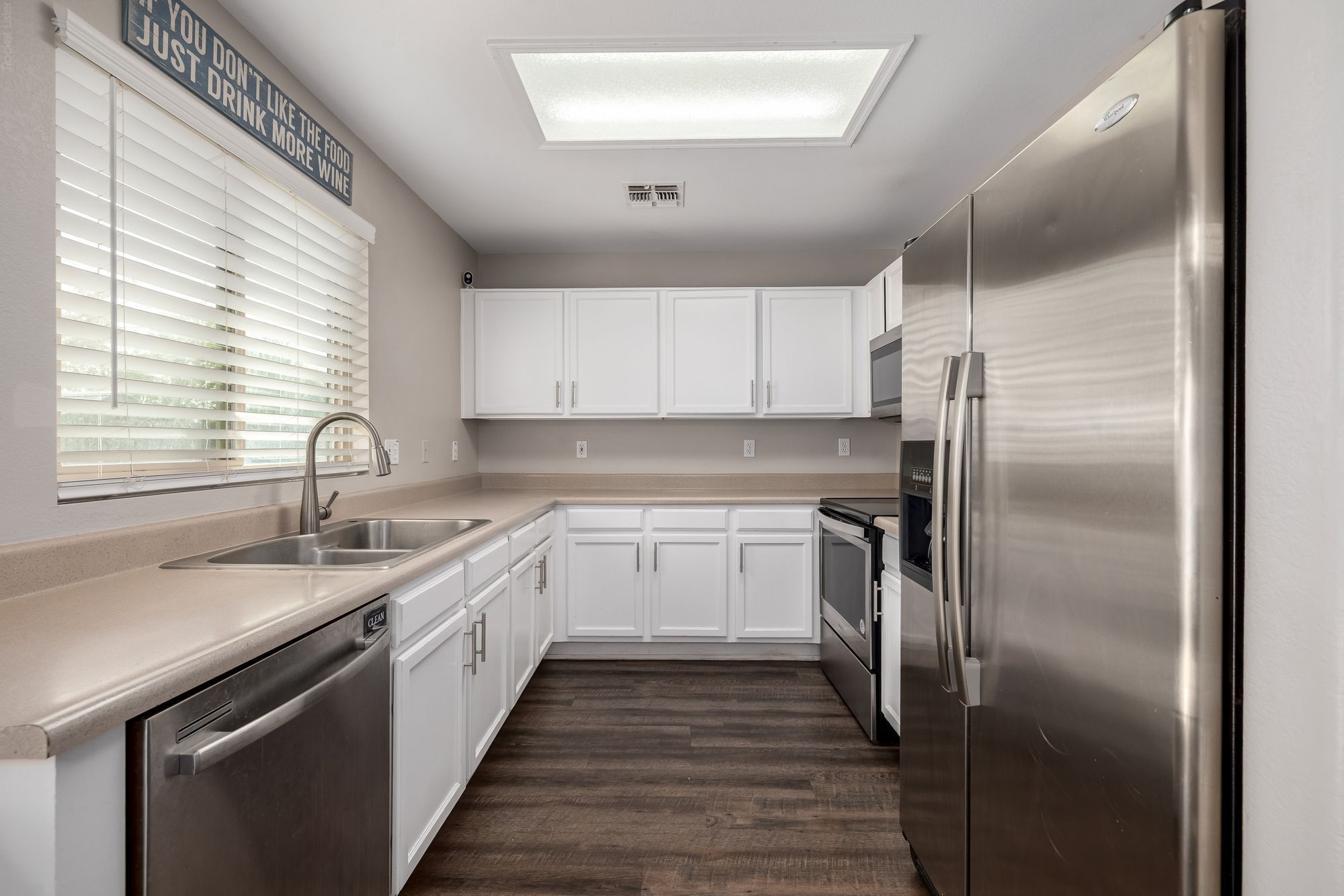 Bright kitchen with white cabinets and stainless appliances