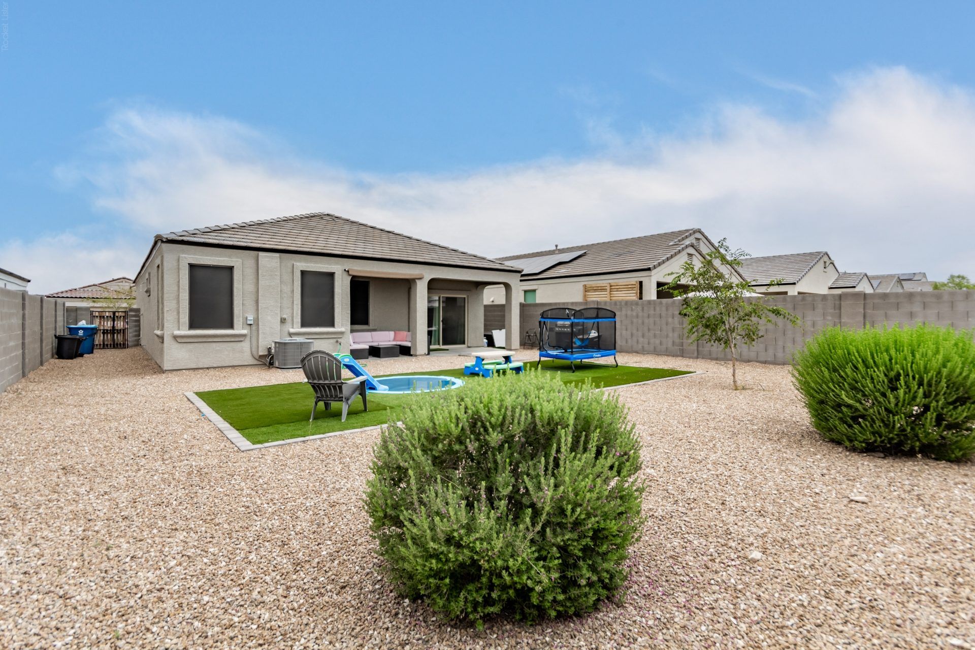 Single-story home with a turf backyard and desert landscaping
