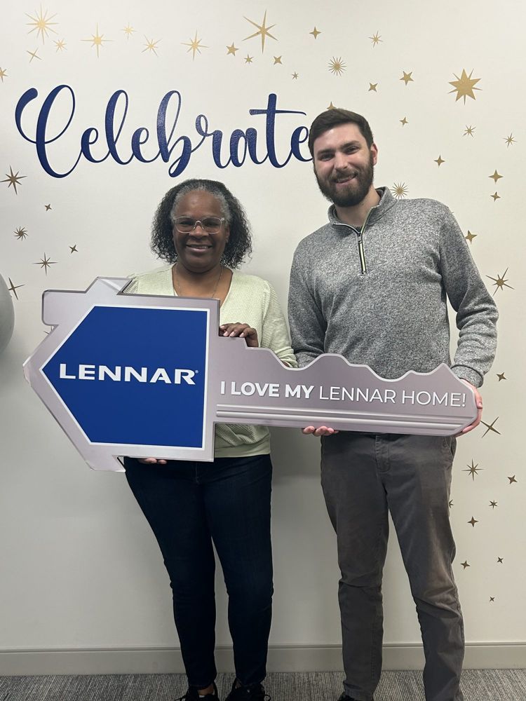 Stephen celebrating with a client holding the key to her new build home